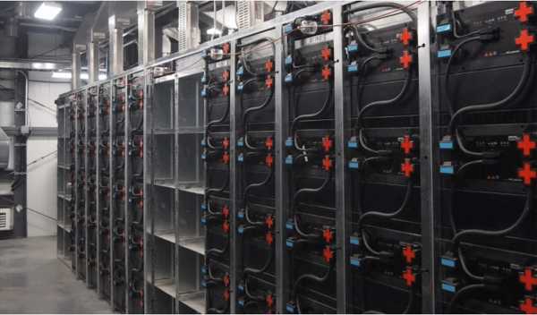 A split image showing a stylish, slim wall-mounted BESS in a garage on one side, and a compact, professional-looking rack cabinet with several battery modules on the other.