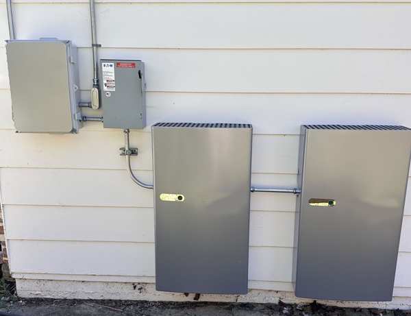 A home with solar panels and a wall-mount battery. An arrow shows sun energy charging the battery during the day, and another arrow shows the battery powering the home at night.